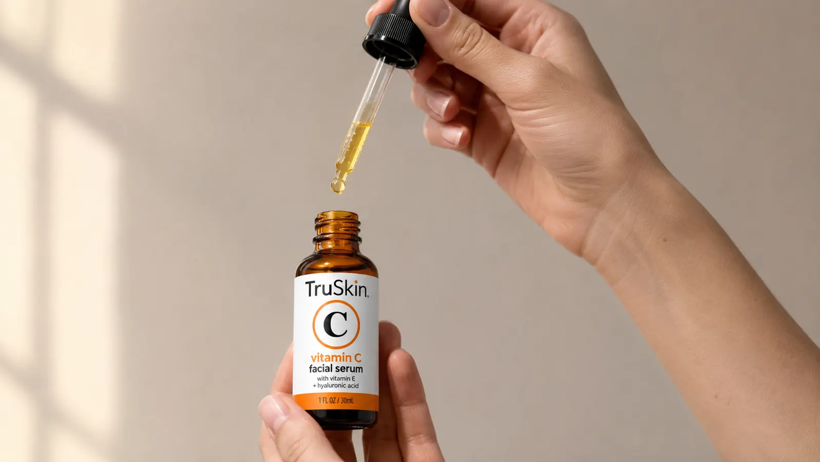 TruSkin Vitamin C Serum bottle with dropper dispensing a few drops onto fingertips