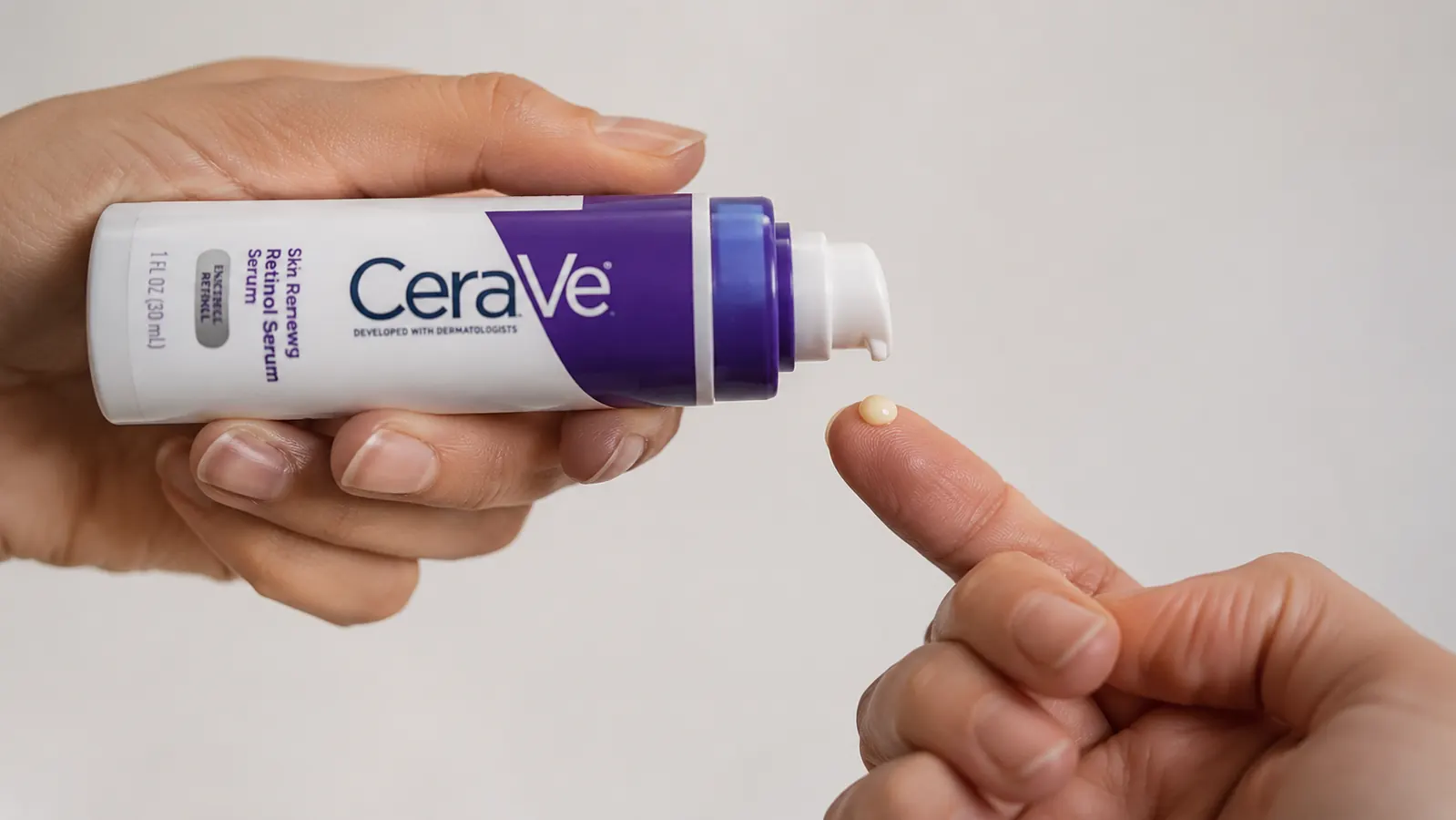 Hand dispensing a small pea-sized amount of CeraVe Retinol Serum onto a fingertip, close-up on a neutral background