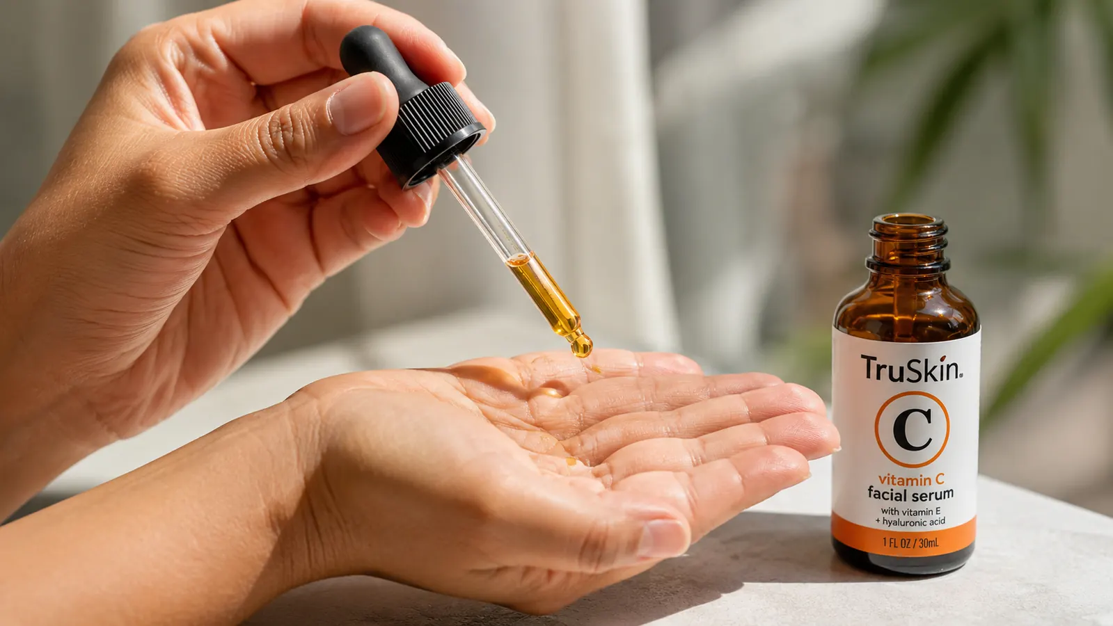 Hand holding a dropper of serum over an open palm, ready to apply